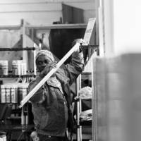 A participant helps put things on a shelf at Restore (b&w).